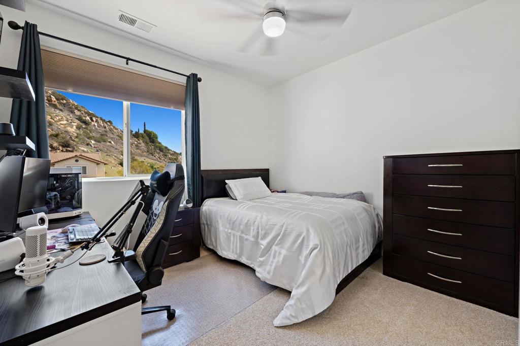 655 Dimaio Way Escondido, CA 92027 - Photo 29 of 46 a bedroom with a bed and a flat tv screen on dresser