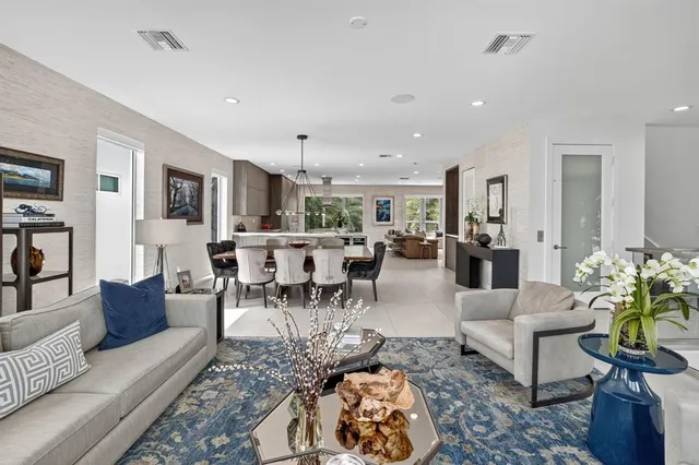 a view of a kitchen with kitchen island a large window cabinets a sink and furniture