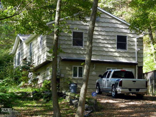 a front view of a house with cars parked