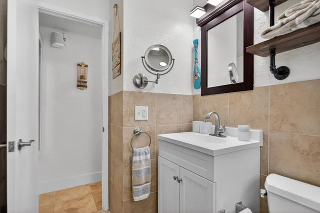 a bathroom with a sink a toilet and a mirror