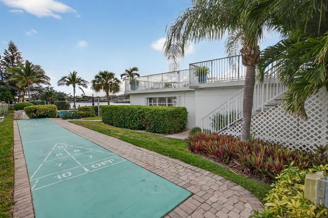a front view of a house with a yard and palm trees