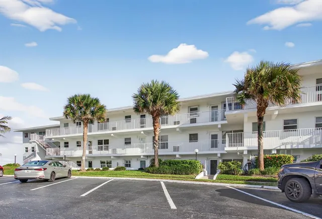 a view of building with cars parked