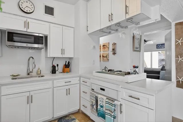 a kitchen with stainless steel appliances white cabinets and a sink