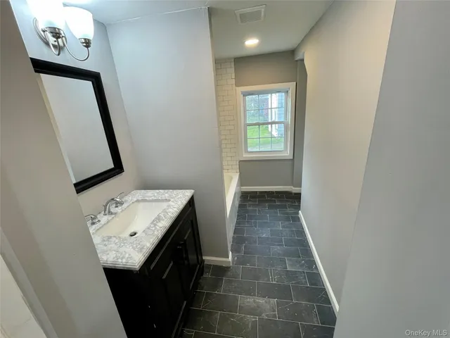 a bathroom with a sink a toilet and mirror