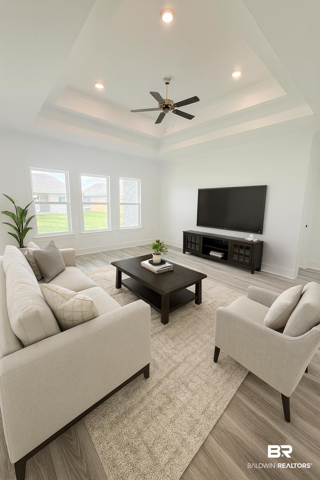 149 Preston Way Gulf Shores, AL 36542 - Photo 4 of 39 Living room featuring light wood-style floors, a raised ceiling, recessed lighting, ornamental molding, and a ceiling fan