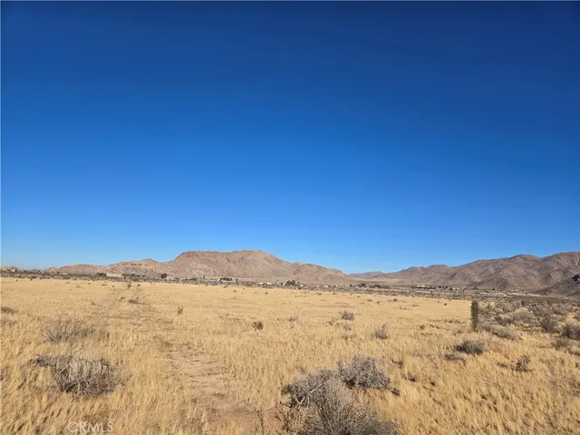 a view of mountain with sunset in background