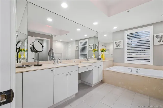 a bathroom with a tub sink and mirror