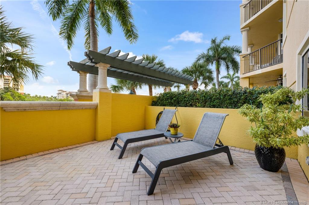 340 Highway 1, Unit 101 Jupiter, FL 33477 - Photo 33 of 42 a view of a patio with table and chairs potted plants and palm tree
