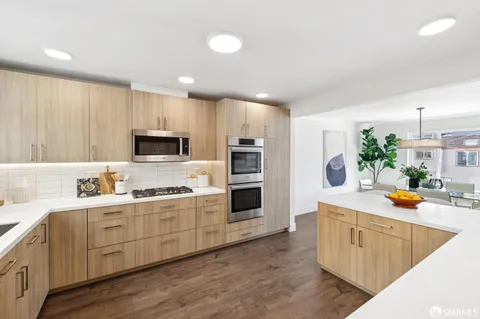 a kitchen with white cabinets stove and refrigerator