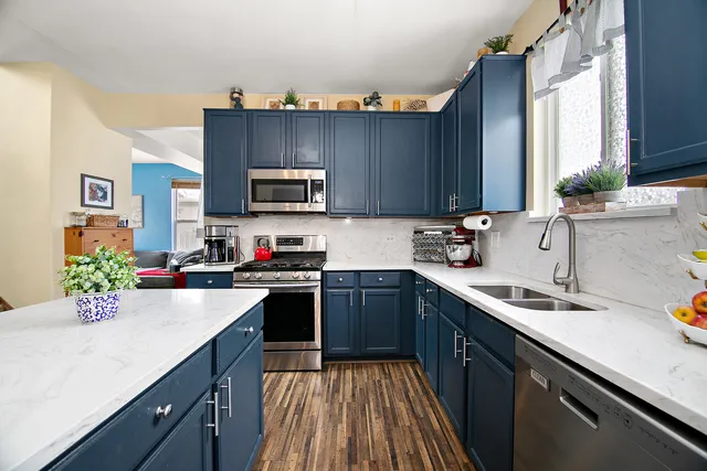 a kitchen with granite countertop a sink dishwasher stove and cabinets with wooden floor