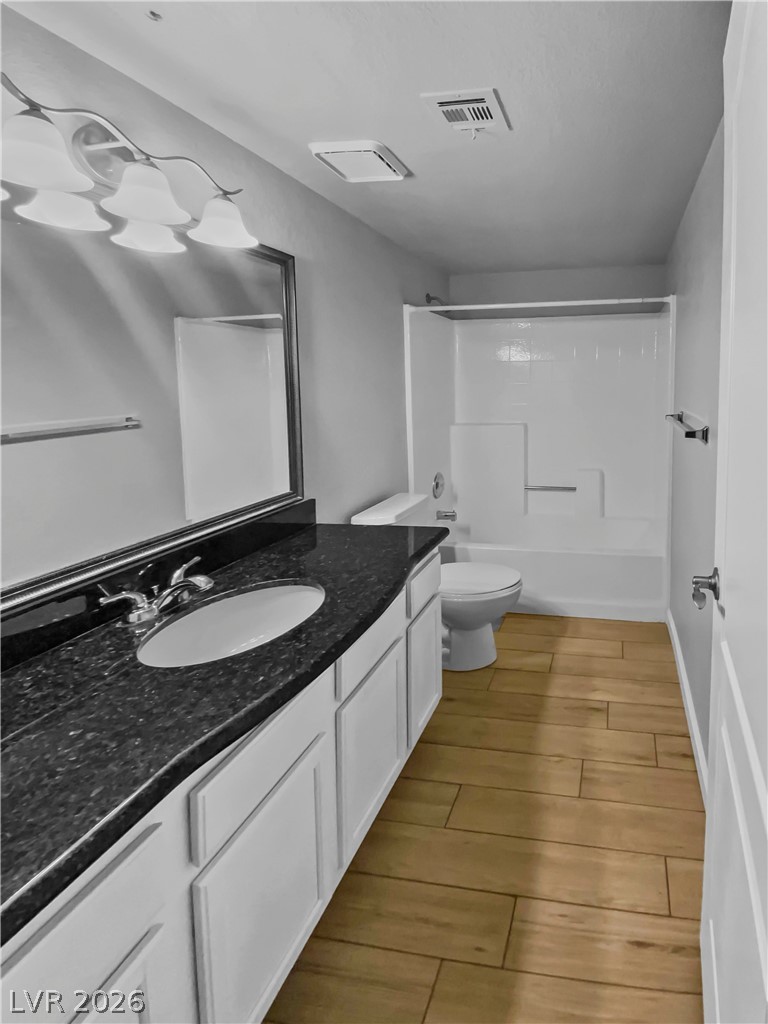 9325 West Desert Inn Road, Unit 278 Las Vegas, NV 89117 - Photo 10 of 17 A dark granite vanity and warm plank flooring enhance this contemporary bathroom.