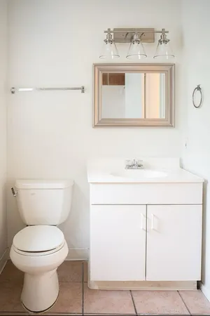 a bathroom with a toilet sink and mirror