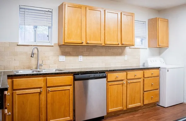 a kitchen with stainless steel appliances granite countertop cabinets and wooden floor