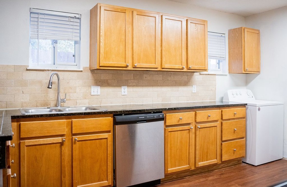 2841 San Gabriel Street Austin, TX 78705 - Photo 21 of 25 Kitchen with washer / dryer, stainless steel dishwasher, healthy amount of natural light, and dark wood-style floors