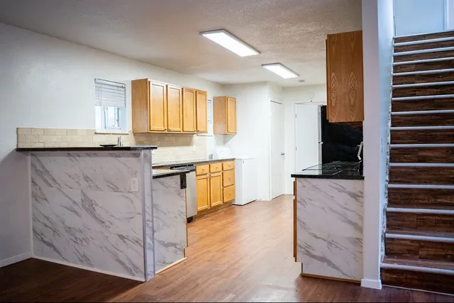 a kitchen with granite countertop wooden cabinets and white appliances