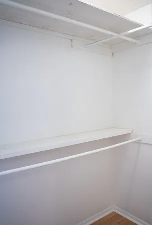 a view of a closet with wooden floor
