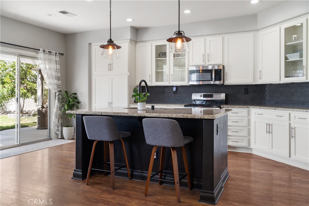 20808 Millbrook Street Riverside, CA 92508 - Photo 21 of 51 a kitchen with stainless steel appliances granite countertop a table chairs sink and cabinets