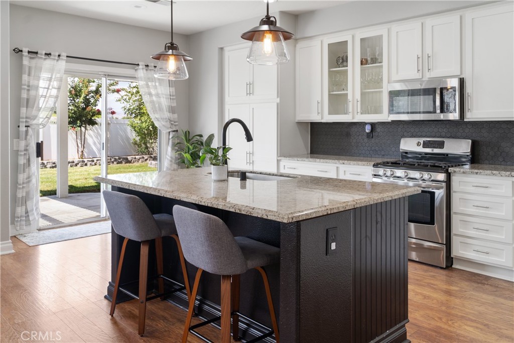20808 Millbrook Street Riverside, CA 92508 - Photo 23 of 51 a kitchen with a table chairs stove and cabinets