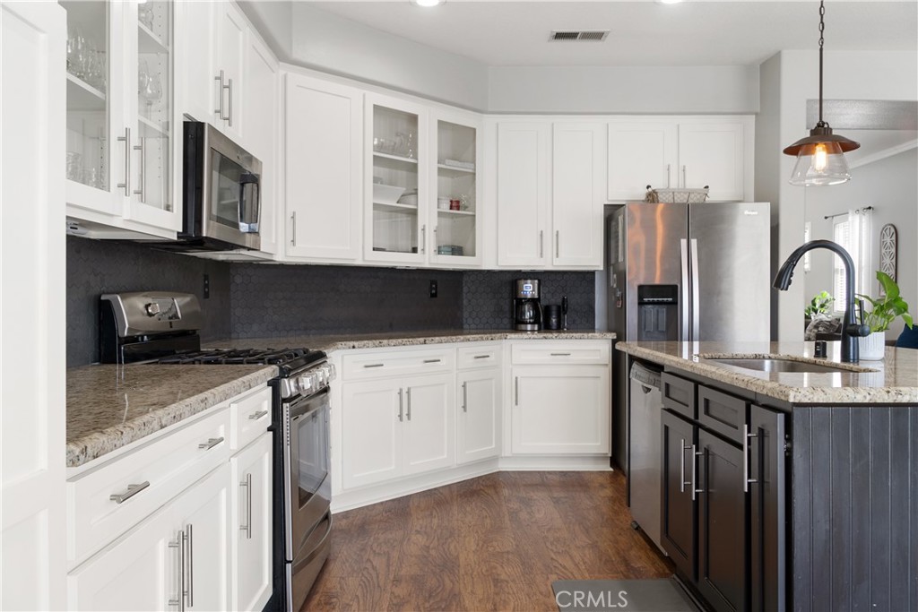 20808 Millbrook Street Riverside, CA 92508 - Photo 24 of 51 a kitchen with stainless steel appliances granite countertop a stove a sink dishwasher and a refrigerator with wooden cabinets