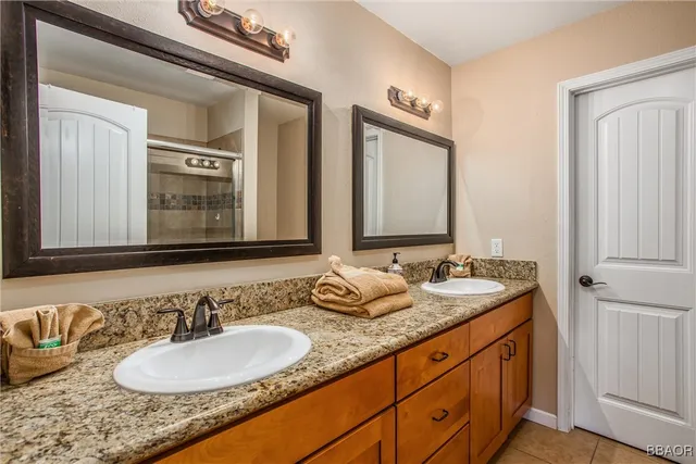 a bathroom with double vanity sinks and a mirror