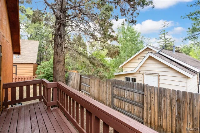 a view of a wooden deck and a yard with wooden fence