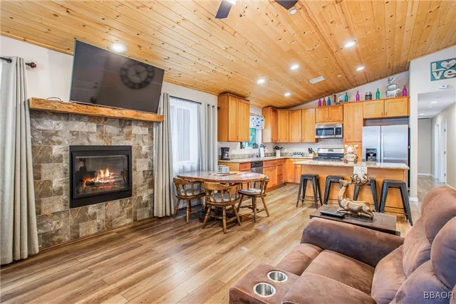 a living room with lots of furniture a kitchen view and a fireplace