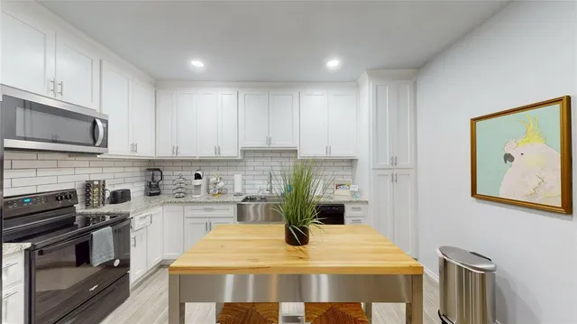 a kitchen with a stove and white cabinets