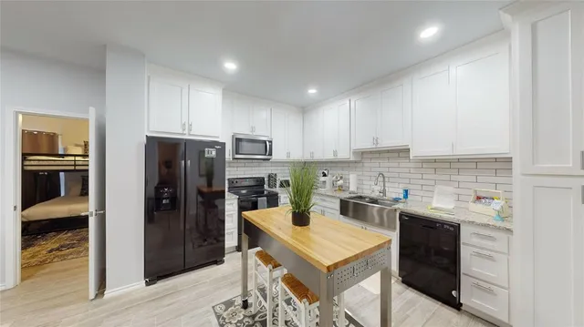 a kitchen with a refrigerator a stove top oven and sink