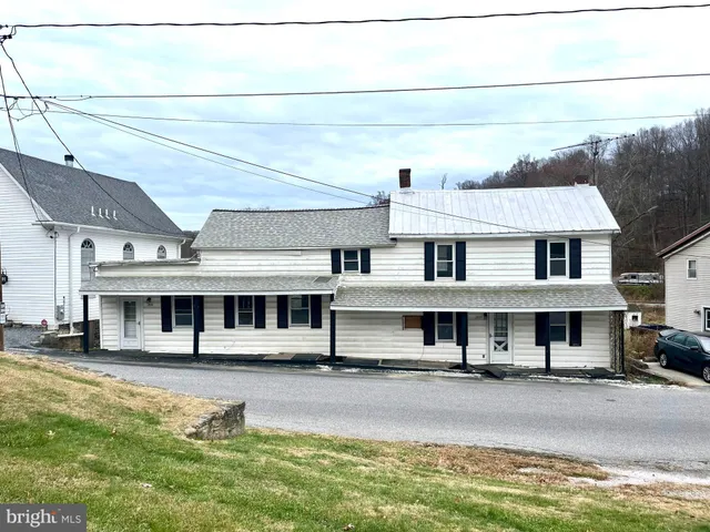 a view of a big house with pool and chairs