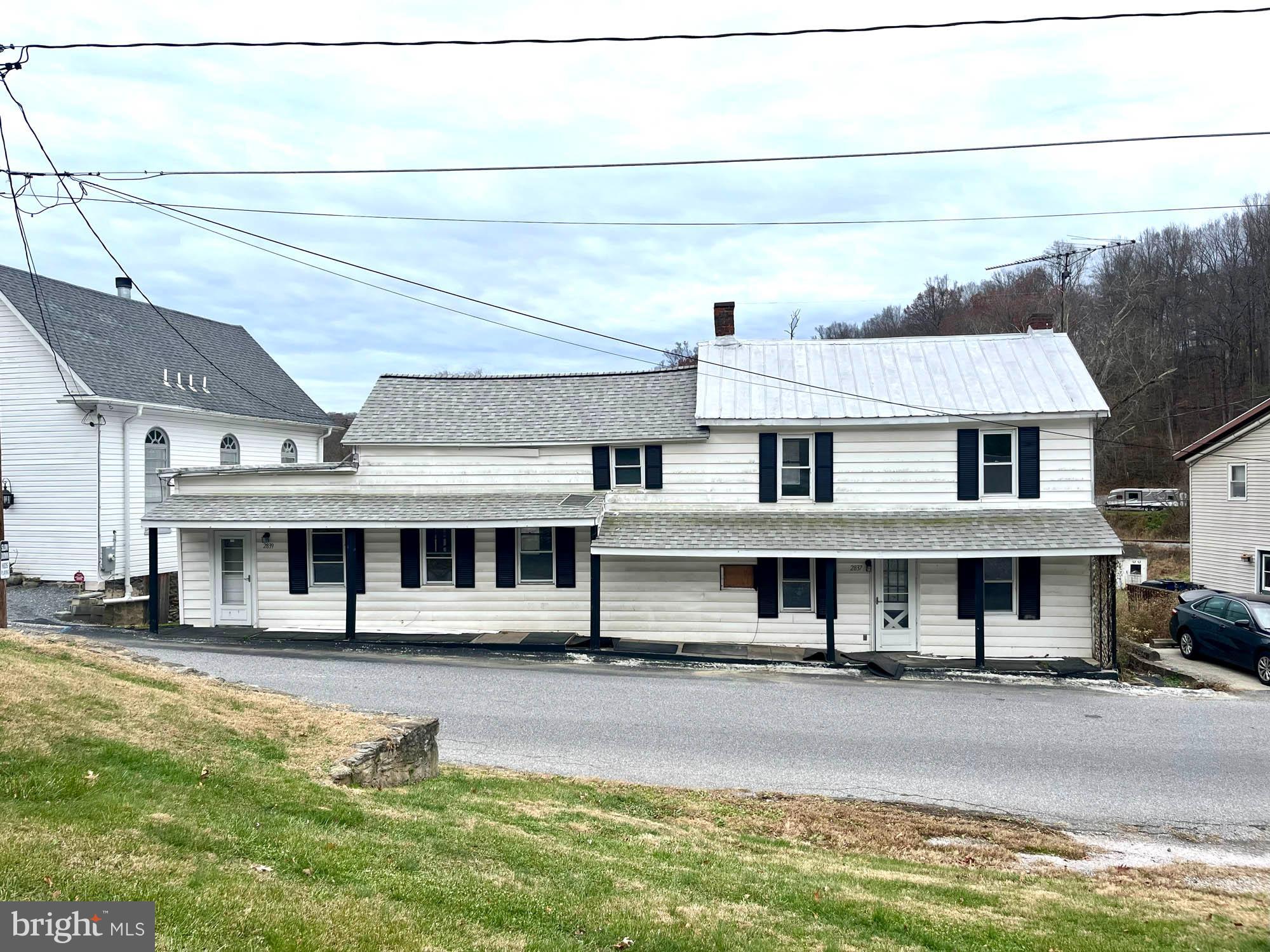 a view of a big house with pool and chairs