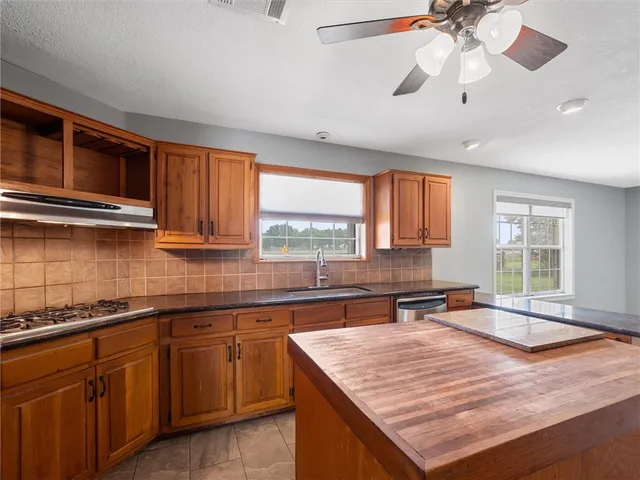 a dining hall with stainless steel appliances granite countertop a refrigerator a sink a washer and dryer with a large window