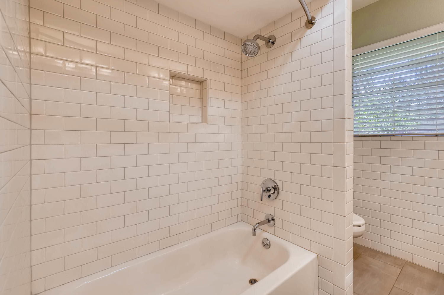 446 Pike Road San Antonio, TX 78209 - Photo 18 of 28 A pristine bath and shower area features gleaming white subway tile, offering both comfort and modern design.