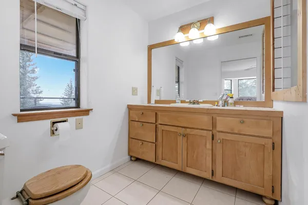 a bathroom with a toilet a sink and mirror
