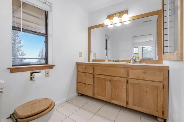 a bathroom with a toilet a sink and mirror