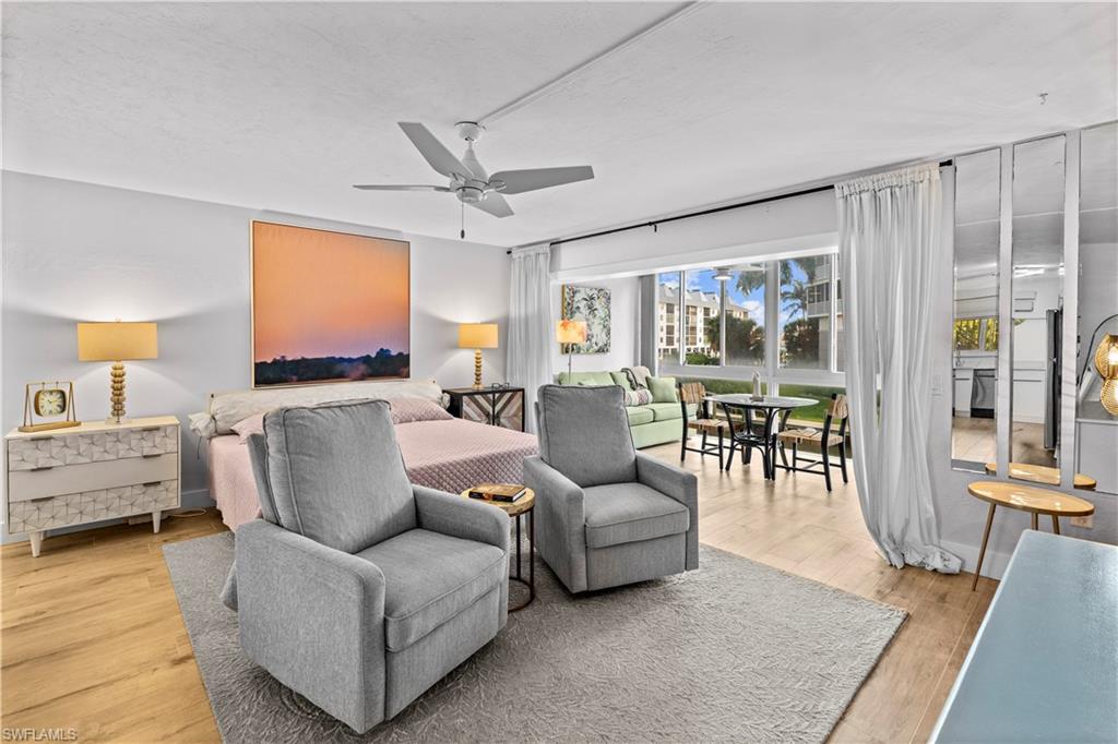 377 Vanderbilt Beach Road, Unit 102 Naples, FL 34108 - Photo 15 of 19 a living room with furniture and a large window