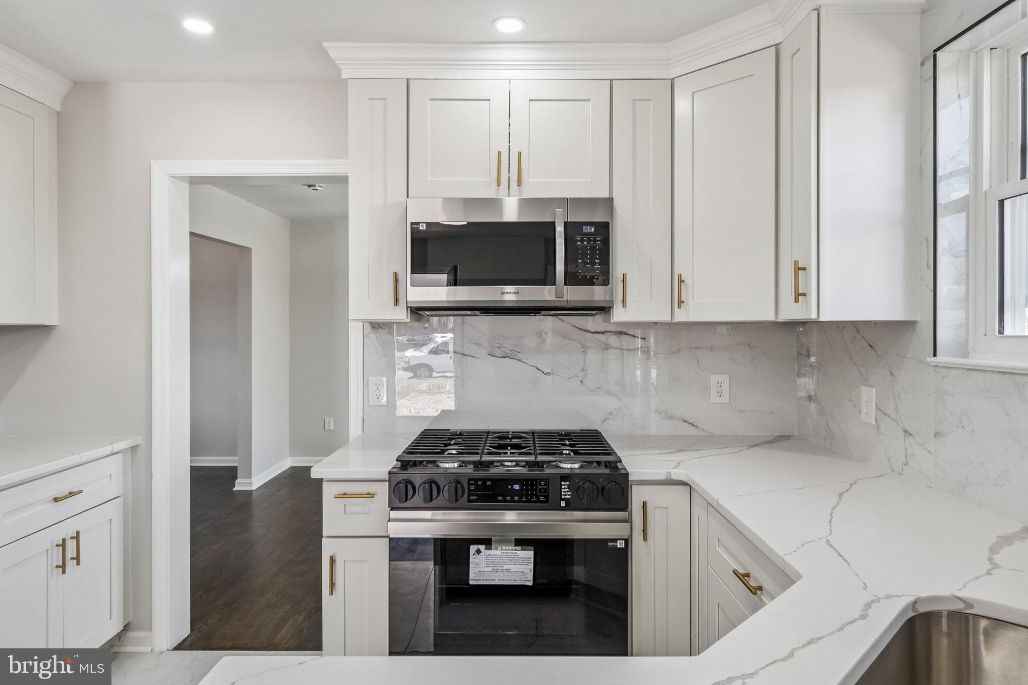 6815 Rolling Road Springfield, VA 22152 - Photo 17 of 40 a kitchen with stainless steel appliances a stove a microwave and sink