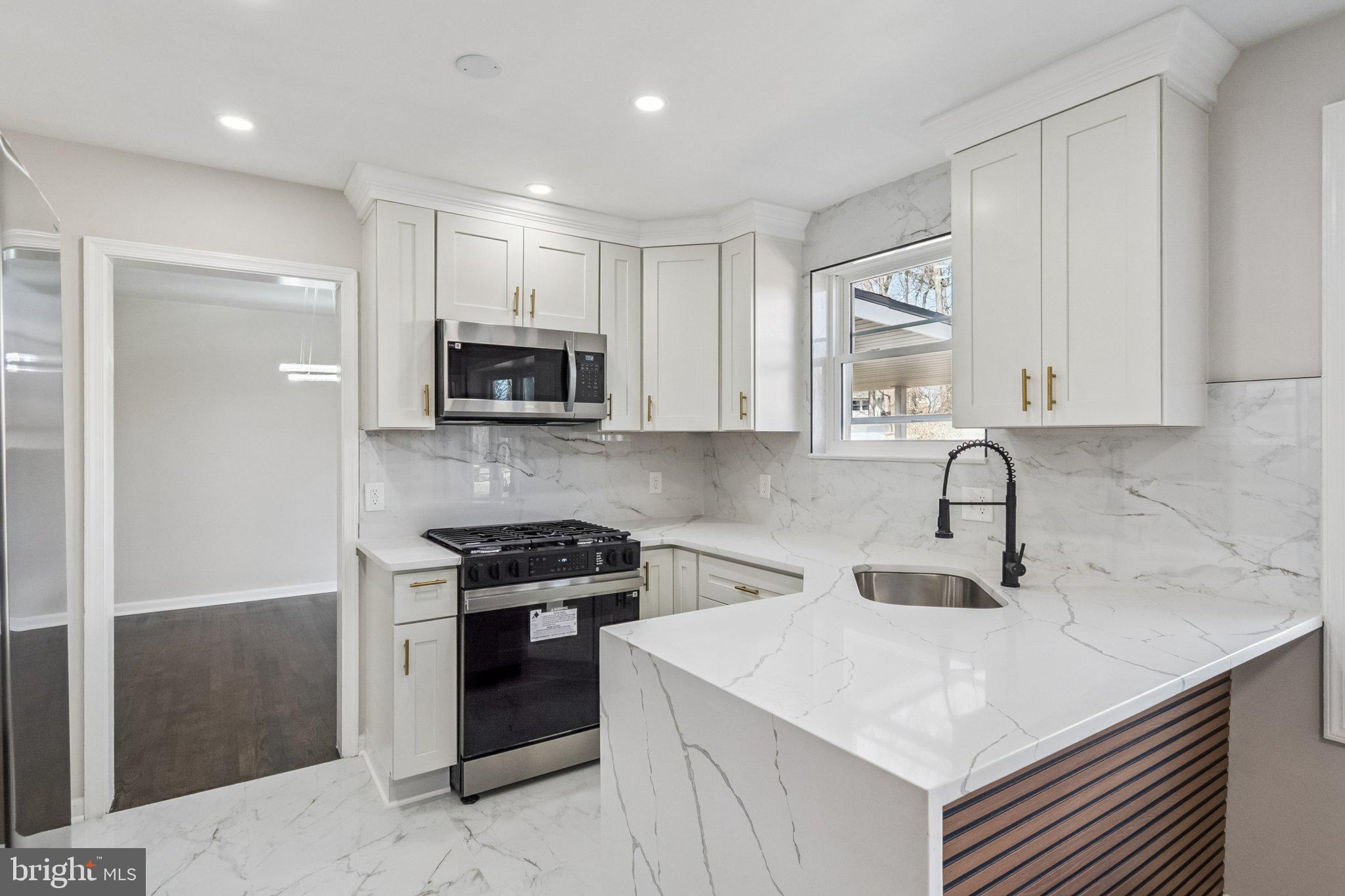 6815 Rolling Road Springfield, VA 22152 - Photo 18 of 40 a kitchen with sink a microwave and cabinets