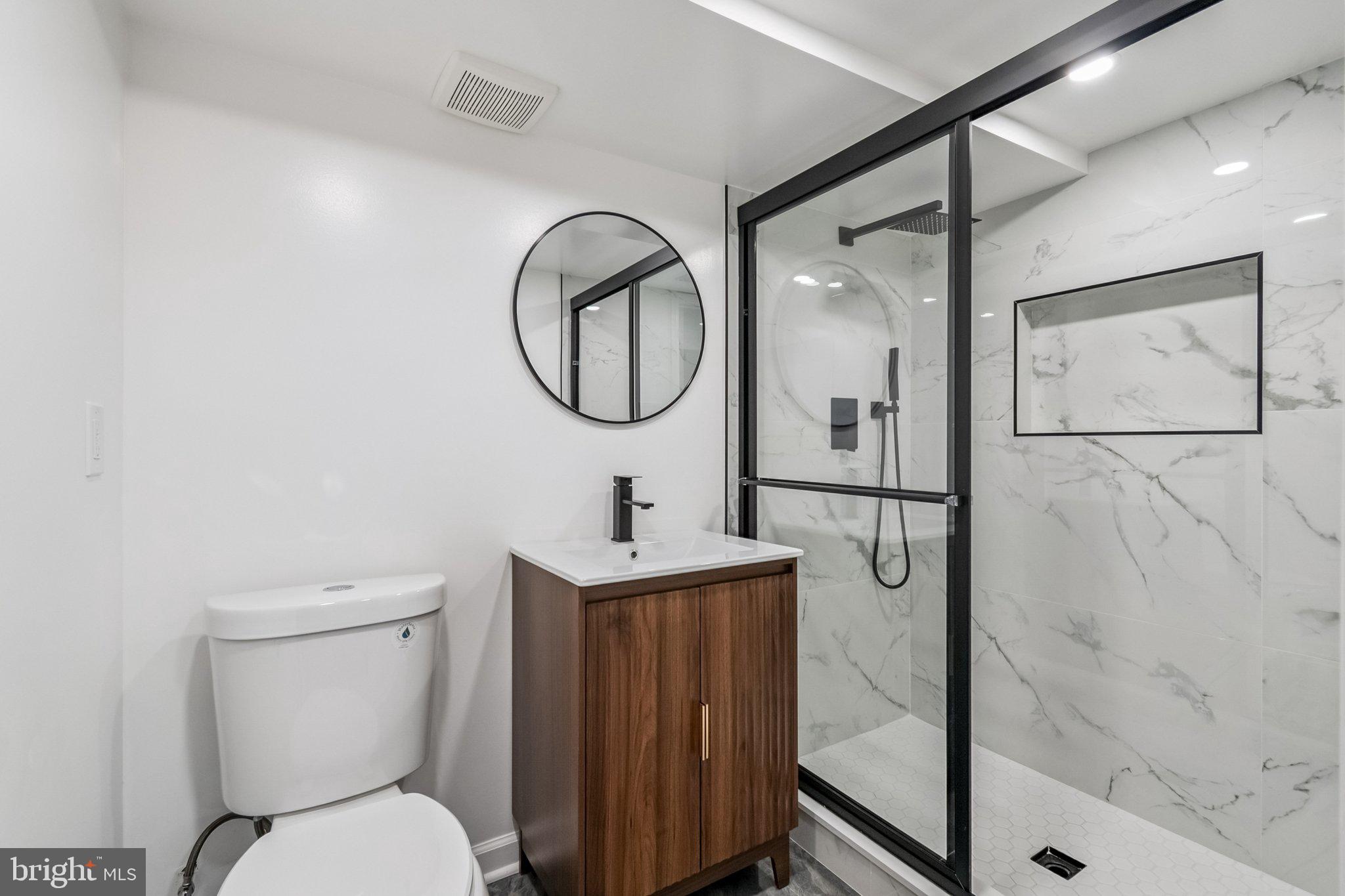 6815 Rolling Road Springfield, VA 22152 - Photo 30 of 40 a bathroom with a toilet sink vanity tub and mirror