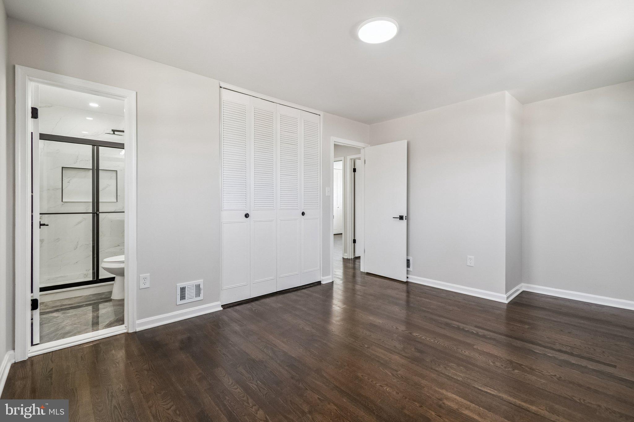 6815 Rolling Road Springfield, VA 22152 - Photo 32 of 40 an empty room with wooden floor and mirror