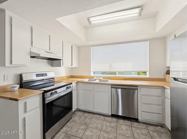 a kitchen with cabinets appliances and a window