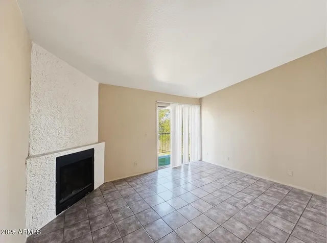 a view of an empty room with a fireplace and a window