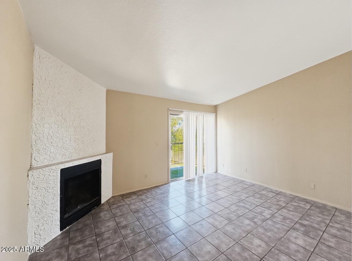 10820 North 16th Avenue, Unit 4 Phoenix, AZ 85029 - Photo 4 of 11 a view of an empty room with a fireplace and a window