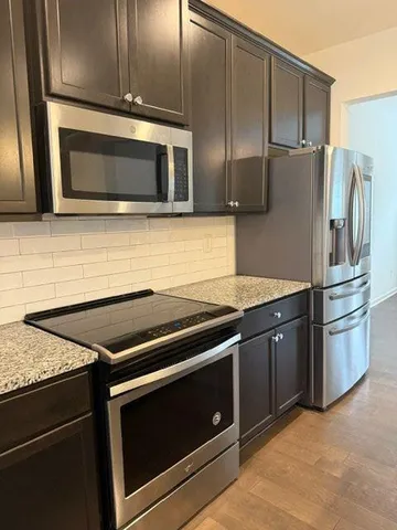 a kitchen with granite countertop stainless steel appliances and wooden cabinets