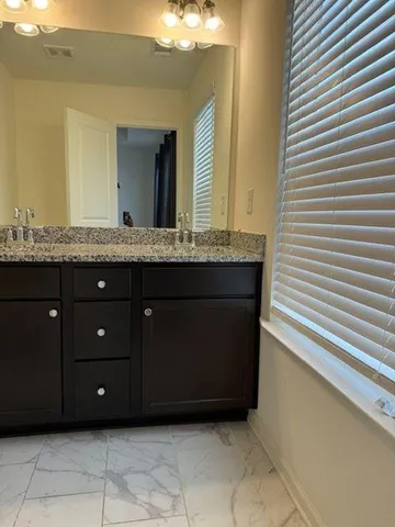 a bathroom with a sink vanity and a mirror