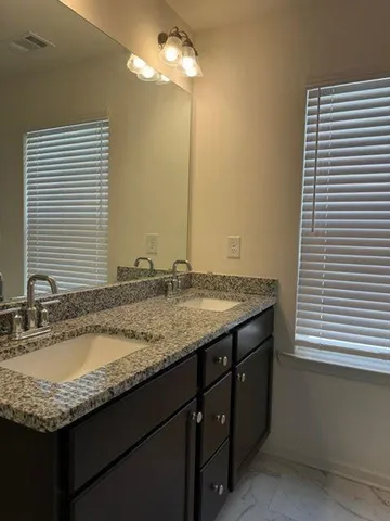 a bathroom with a granite countertop sink and a mirror