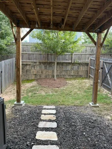 a backyard of a house with a lots of trees and entertaining space