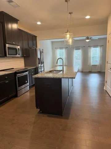 a kitchen with kitchen island stainless steel appliances a sink stove and refrigerator