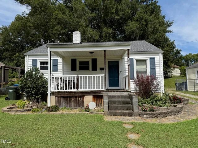 a view of a house with a yard and potted plants