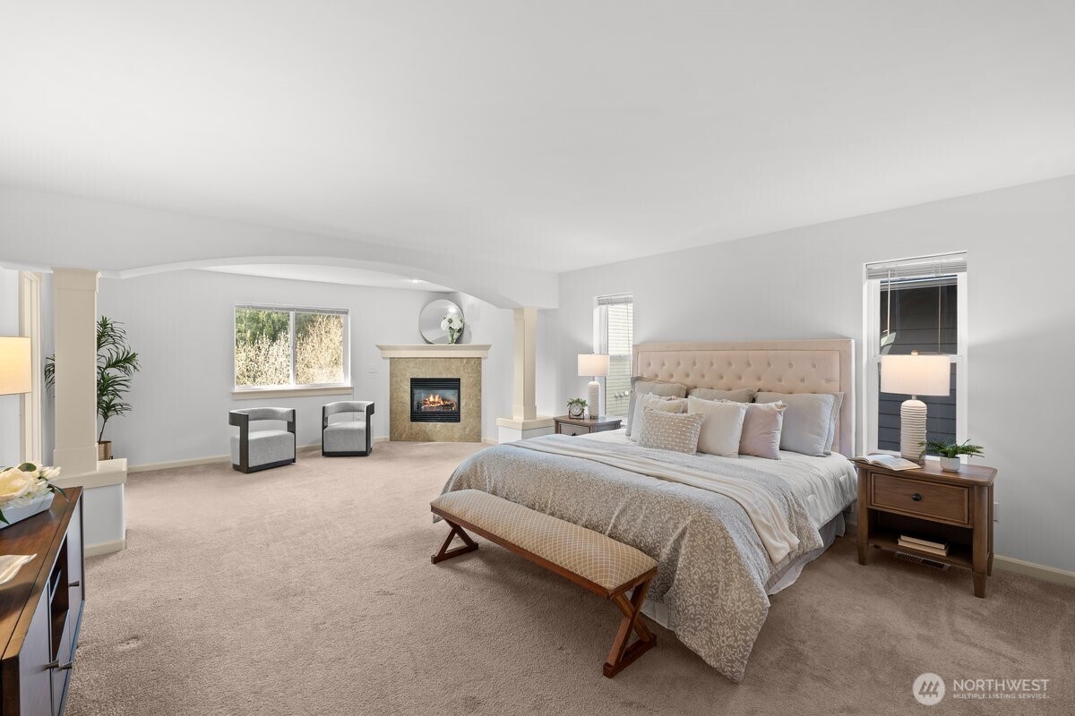 603 194th Place Southeast Bothell, WA 98012 - Photo 17 of 30 a spacious bedroom with a bed a table and a fireplace