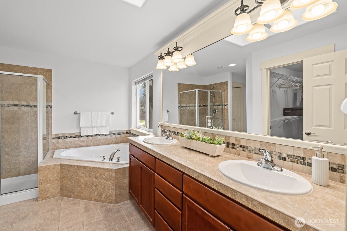 603 194th Place Southeast Bothell, WA 98012 - Photo 19 of 30 a bathroom with a granite countertop double vanity sink a mirror and a bathtub